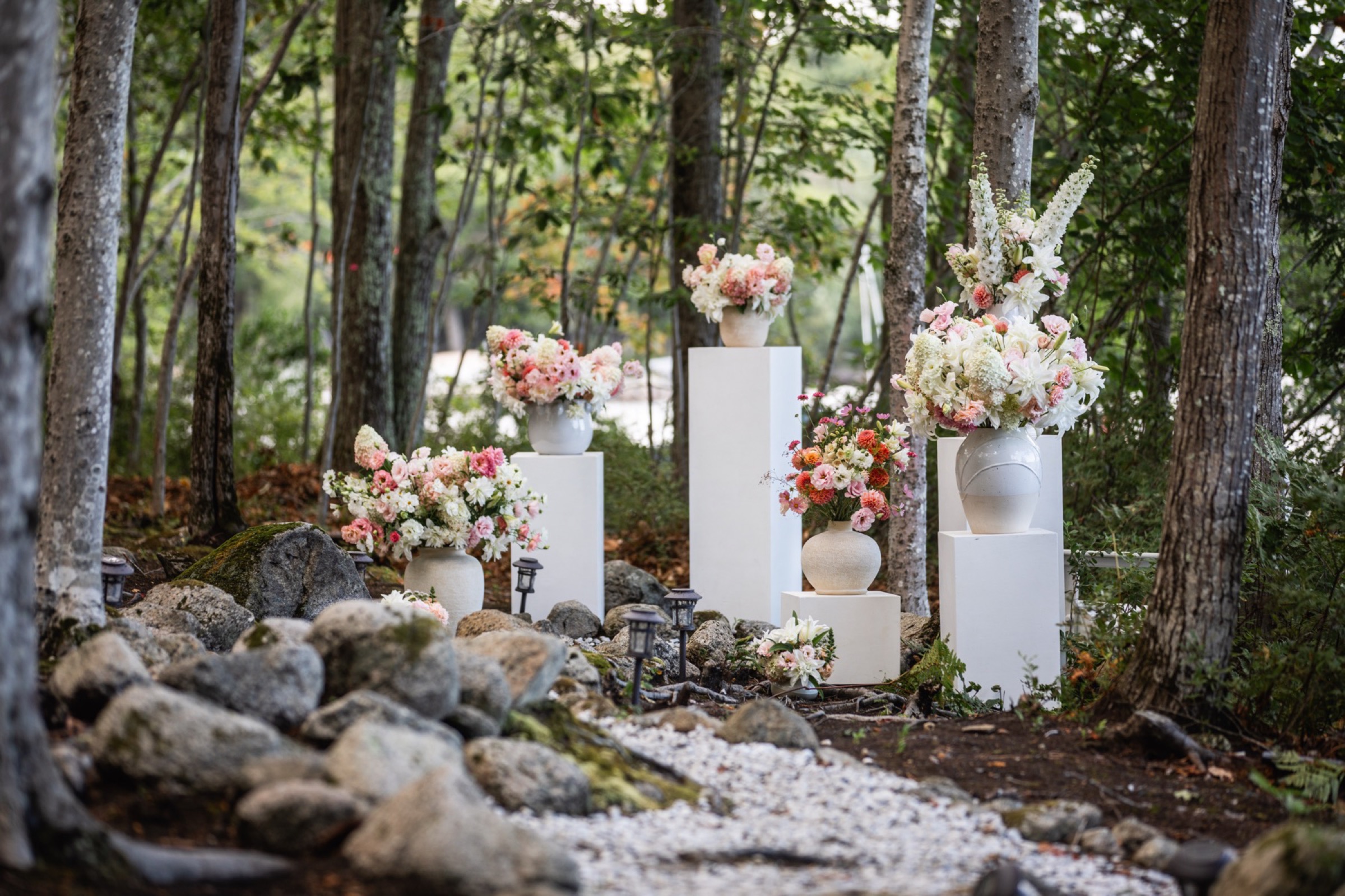A ceremony clearing in the pines with pedestal arrangements
