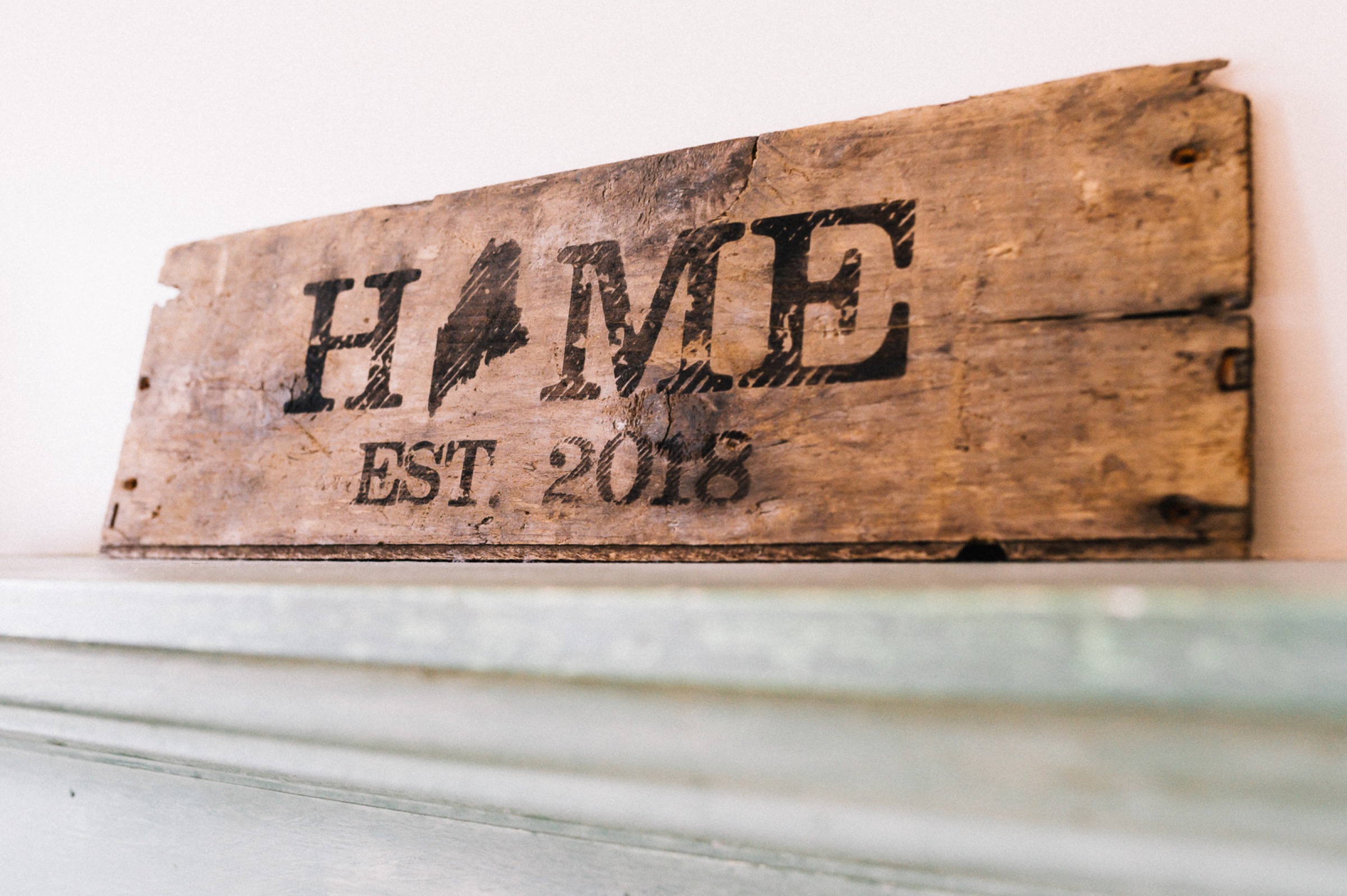 Hand-painted wooden sign reading Home, Maine, Est. 2018