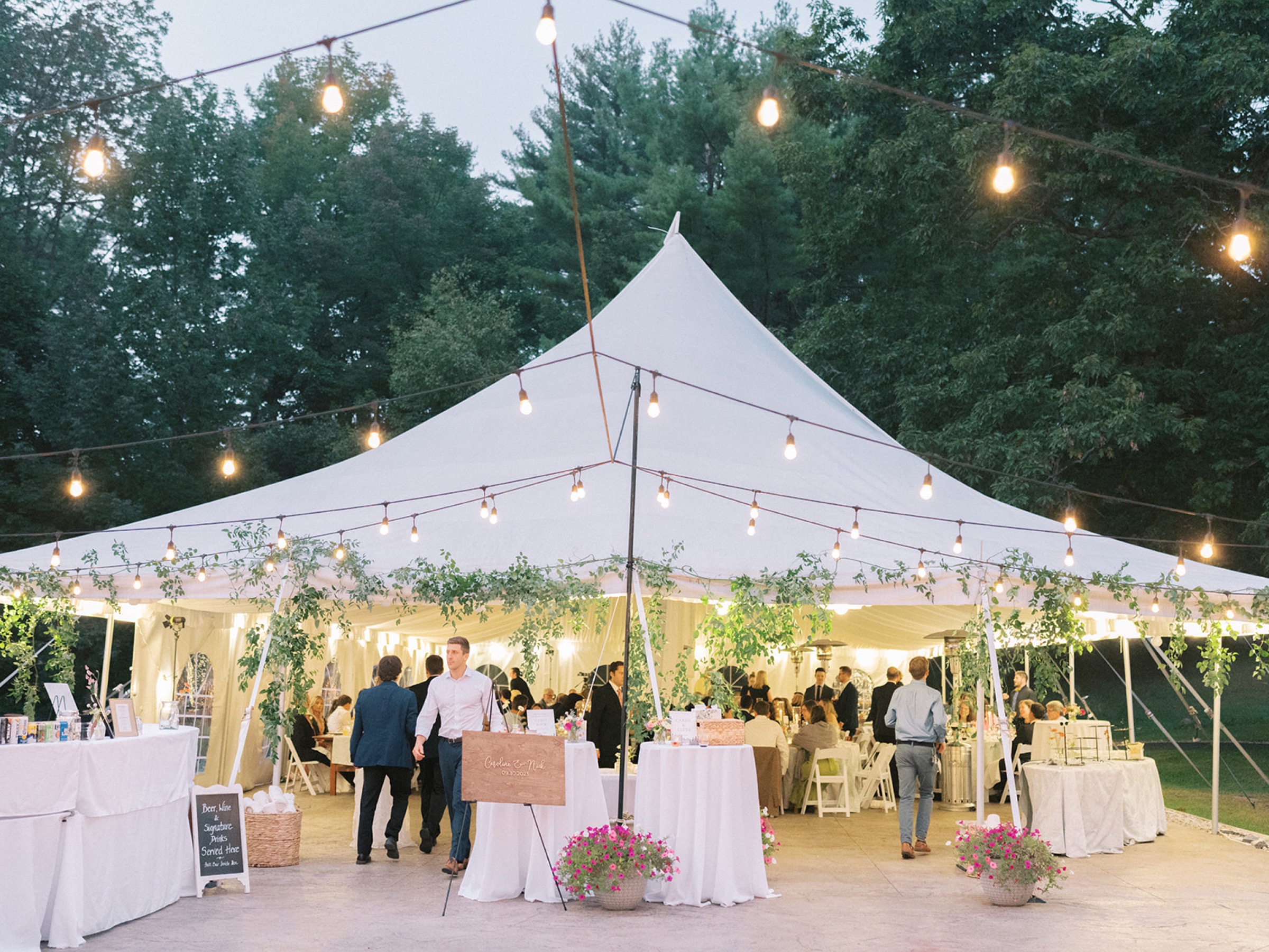 Sailcloth tent reception at dusk, string lights over farm-grown centerpieces